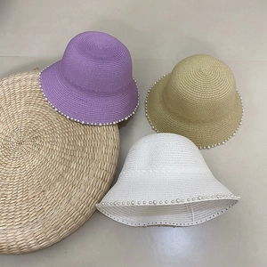 Detailed straw sun hat texture featuring elegant pearl trim in purple, khaki, and white