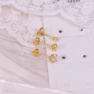 Macro detail of three gold plated S925 sterling silver star earrings with clear gems