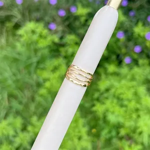 Nahaufnahme eines gestuften, 18 Karat vergoldeten Rings mit wellenförmigem Design
