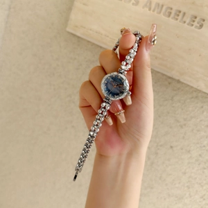 Detail of luxury women's bracelet watch with pearl and marquise rhinestone silver strap