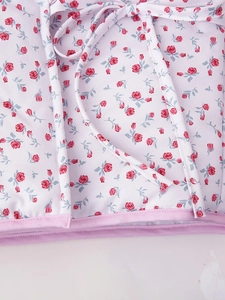 Detailed macro shot of white floral jacket fabric with red roses and pink hem piping
