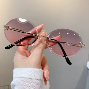 Détail de lunettes de soleil ovales sans monture avec verres dégradés rose et violet