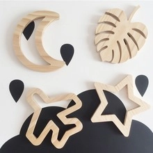 Detail of wooden nursery wall hangings with moon, leaf, star and airplane shapes