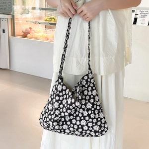 Detailed close-up of a lightweight canvas tote bag featuring a white daisy floral pattern