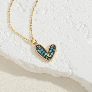 Macro shot of heart pendant necklace with colorful shell inlay and gold chain