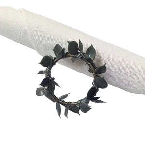 Rustic farmhouse green eucalyptus napkin ring on a beige linen napkin for table decor