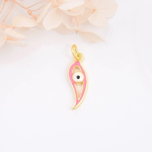 Macro shot of gold-plated crescent pendant with pink enamel and evil eye detail