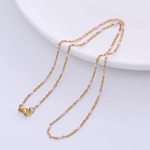 Detail of gold O-chain necklace with pink beads and lobster clasp on white plate