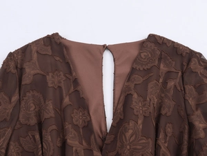 Détail de robe en tulle marron foncé avec flocage floral et ouverture goutte au dos