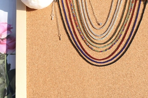 Macro shot of colorful rhinestone tennis necklaces in claw setting on wood surface