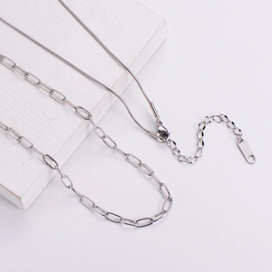 Double-layered titanium steel necklace with snake and paperclip chains on white stone