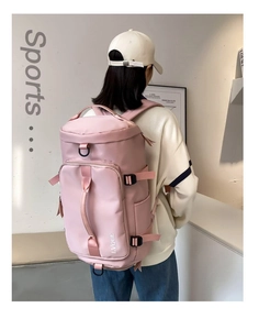 Detail of pink nylon travel backpack showing functional compartments and adjustable straps