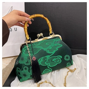 Details von Bambusgriff und smaragdgrüner Stickerei auf der Vintage-Schultertasche