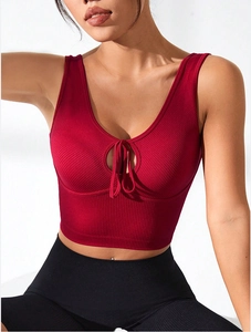 Detail of dark red ribbed crop top featuring front cutout and decorative lace-up detail