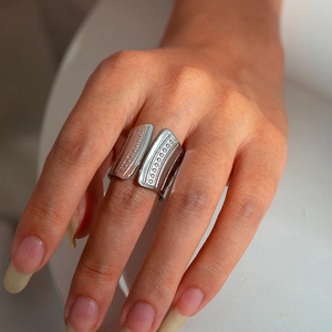 Adjustable wide stainless steel ring with textured engraved pattern on model finger