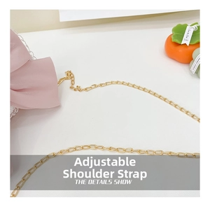 Detail of adjustable golden chain strap with pink silk ribbon for kids handbag