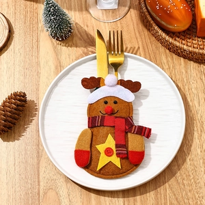 Detail of reindeer-shaped felt cutlery holder on a plate with golden knife and fork