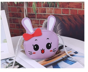 Close-up of a purple cartoon rabbit crossbody bag with a red bow and petal zipper