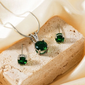 Parure de bijoux luxueuse avec cristaux vert émeraude sur pierre et soie dorée