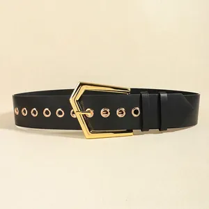 Detail of black elastic belt with gold hexagonal buckle and metallic eyelet decor
