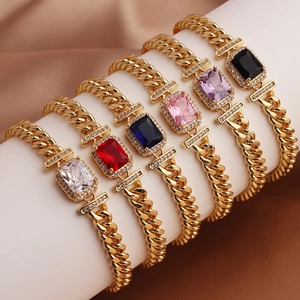 Detail of gold Cuban bracelets with multicolored square-cut zircons on a display stand
