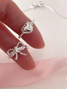 Detailed view of S925 silver heart and bow rings with beaded band and lace design
