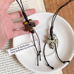 Tiger eye and spotted stone flower pendant necklace on wax rope in a lifestyle setting