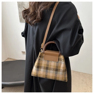 Retro plaid wool handbag featuring wooden round handles and leather strap on model