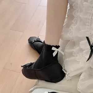 Lace frill JK crew socks with white bows paired with black ballet flats for women