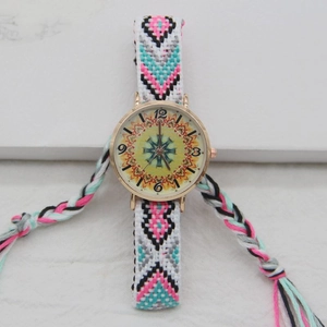 Close-up of bohemian woven strap and gold watch face with vintage mandala pattern