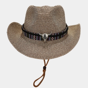 Detail of western straw hat with ethnic embroidered band and silver bull head ornament