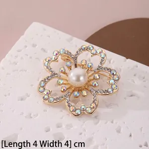 Détail macro d'une élégante broche fleur de 4cm avec perle blanche et cristaux