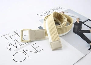 Detail of striped beige canvas belt with double D-ring buckle and faux leather finish
