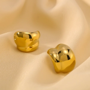Chic twisted hollow C-shaped gold earrings in a minimalist design on silk fabric