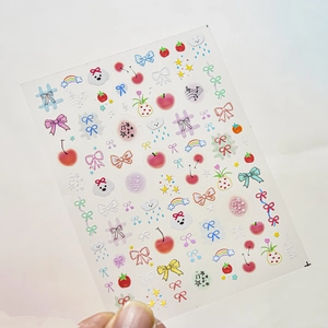 Detail showing thin nail art sticker with cute hand-drawn puppies and cherry icons