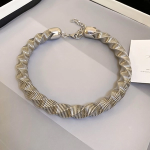 Macro shot of silver-tone thick choker necklace featuring twisted thread texture and lobster clasp