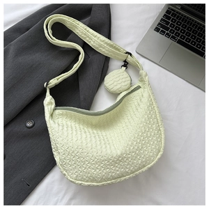 Detail of light green puckered texture crossbody bag with adjustable strap and coin purse