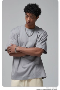 Men's silver link chain necklace and bracelet set styled with a gray oversized t-shirt