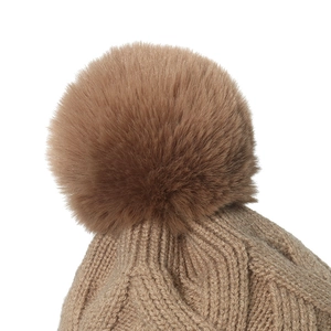 Détail d'un bonnet en maille kaki avec tissage texturé et grand pompon en fausse fourrure