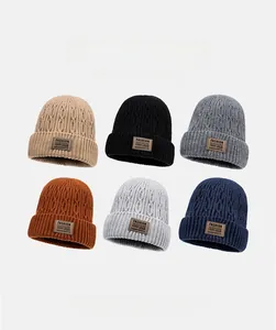 Detail view of cable knit beanies in six colors with vintage leather patches