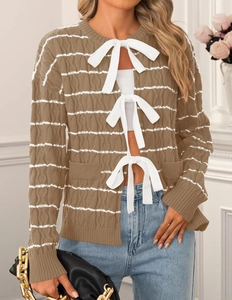 Detail showing brown striped knit cardigan with white bow closures and cable knit texture