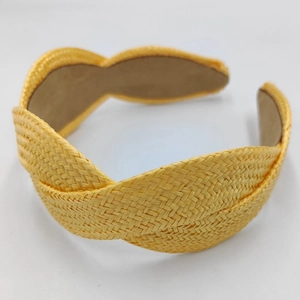 Detailed view of yellow raffia braid texture on a handmade wide fashion headband