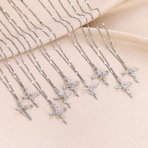 Detailed close-up of multiple silver cross necklaces with engraved birth flowers