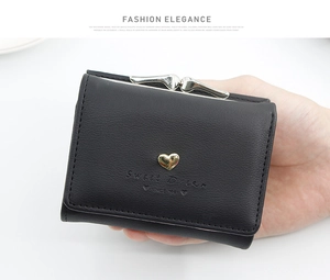 Detail of black mini tri-fold wallet with gold heart charm and Sweet Dream engraving