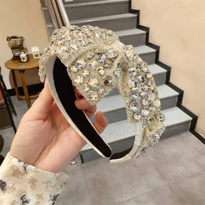 Detailansicht eines weißen Strass-Haarreifens mit Schleifen-Design und Glitzersteinen