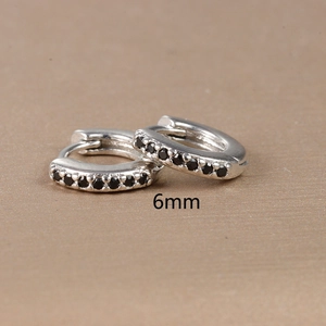 Macro shot of 6mm silver hoop earrings with black zircon stones and polished finish