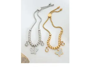 Detail of adjustable butterfly charm beaded bracelets in gold and silver finishes