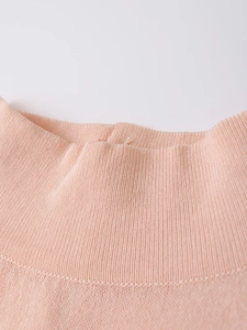Détail du pull en maille pêche montrant la texture côtelée fine du col semi-montant