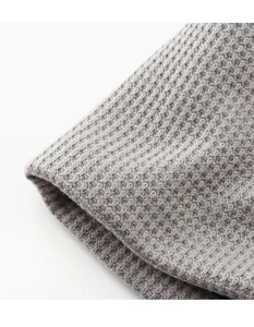Macro view of grey waffle knit fabric texture showing breathable square pattern