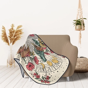 Detailed view of astrology-themed flannel blanket draped over a neutral living room sofa